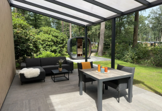 Overdekt terras met moderne tuinmeubels bij Veluwe Suite met sauna op Camping Samoza in Nederland.