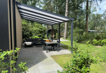 Terrazza moderna con arredi eleganti sotto una tettoia presso Veluwe Suite con sauna al Camping Samoza, Olanda.
