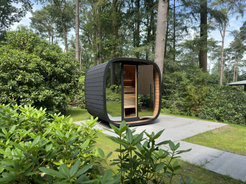 Moderne buitensauna bij Veluwe Suite op Camping Samoza in Nederland omringd door groene natuur.