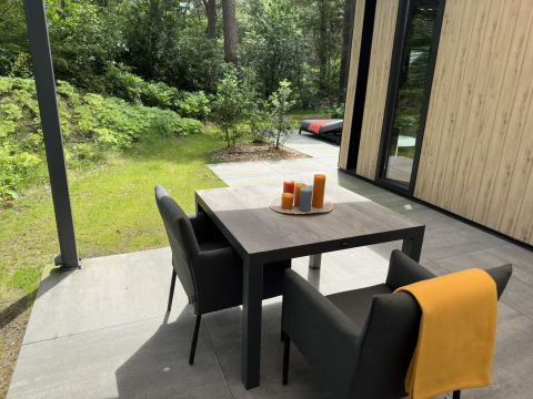 Terras met tafel, stoelen en kaarsen bij Veluwe Suite met sauna op Camping Samoza in Nederland.