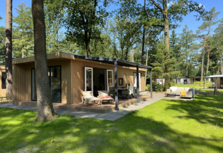 Buitenaanzicht van de Veluwe Villa lodge op Camping Samoza in Nederland, omringd door bomen en natuur.
