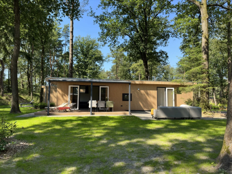 Veluwe Villa lodge op Camping Samoza in Nederland, moderne houten woning met terras in het bos.