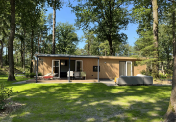 Veluwe Villa lodge op Camping Samoza in Nederland, moderne houten woning met terras in het bos.