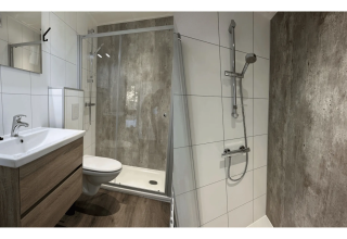 Moderne badkamer met glazen douche, houten kast en witte tegels in Veluwe Villa op Camping Samoza.