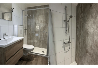 Bagno moderno con doccia in vetro, mobile in legno e piastrelle bianche alla Veluwe Villa di Camping Samoza.