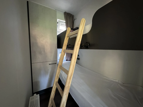 Kamer met stapelbed, houten ladder en kleerkast in Veluwe Villa bij Camping Samoza, Nederland.