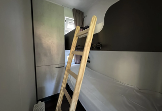 Kamer met stapelbed, houten ladder en kleerkast in Veluwe Villa bij Camping Samoza, Nederland.