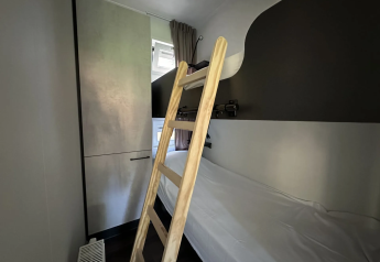 Kamer met stapelbedden, houten ladder en kast in Veluwe Villa op Camping Samoza, Nederland.