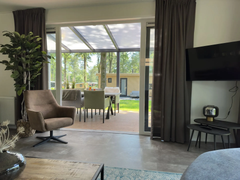 Woonkamer van Veluwe Villa bij Camping Samoza, modern interieur, zicht op terras en tuin in Nederland.