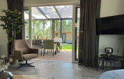 Woonkamer van Veluwe Villa bij Camping Samoza, modern interieur, zicht op terras en tuin in Nederland.