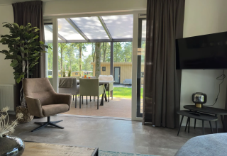 Woonkamer van Veluwe Villa bij Camping Samoza, modern interieur, zicht op terras en tuin in Nederland.