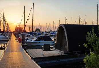 Tramonto su yacht e una tiny house sull'acqua a Water Bubbles, Marina Parcs Almere, Paesi Bassi.