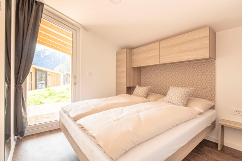 Camera luminosa presso Chalets & Glamping Nassfeld 1, Austria, con letto matrimoniale e vista montagna.