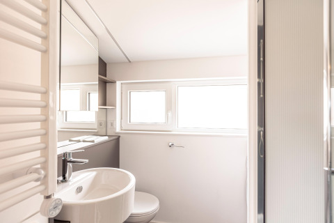 Bagno moderno e luminoso con finestre, lavandino, specchio e doccia presso Chalets & Glamping Nassfeld 1, Austria.