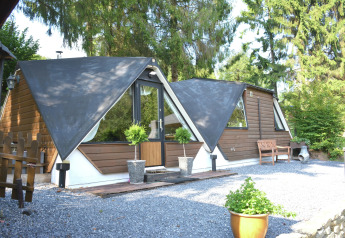 Udendørs billede af chalet Mise Au Vert med unikke trekantede tage, grønne omgivelser og grusareal.