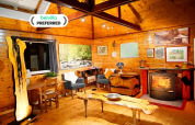 Acogedora sala de estar en la cabaña Quarreux 27 en Bélgica con chimenea y muebles de madera natural.