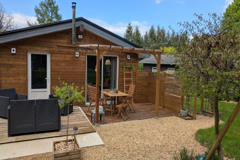 Houten terras met zithoek en pergola bij Chatillon 67 lodge in België, omgeven door tuin.