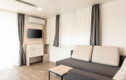 Soggiorno moderno con divano, TV e tavolino al Chalets & Glamping Nassfeld 2 in Austria.