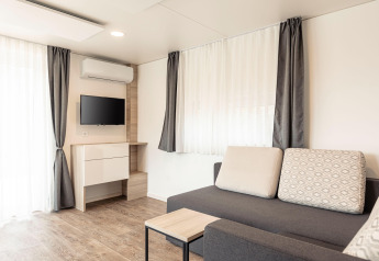Soggiorno moderno con divano, TV e tavolino al Chalets & Glamping Nassfeld 2 in Austria.