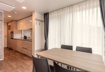 Moderne eet- en keukenruimte in een chalet bij Chalets & Glamping Nassfeld 2 in Oostenrijk met grote ramen.