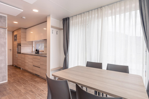 Moderne spisestue og køkkenområde i et chalet ved Chalets & Glamping Nassfeld 2 i Østrig med store vinduer.