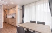 Sala da pranzo e cucina moderne in uno chalet di Chalets & Glamping Nassfeld 2 in Austria con ampie finestre.
