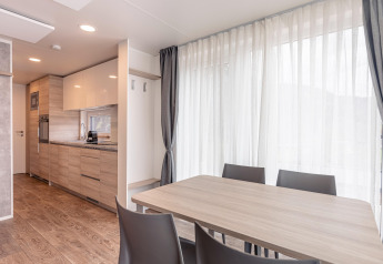 Sala da pranzo e cucina moderne in uno chalet di Chalets & Glamping Nassfeld 2 in Austria con ampie finestre.