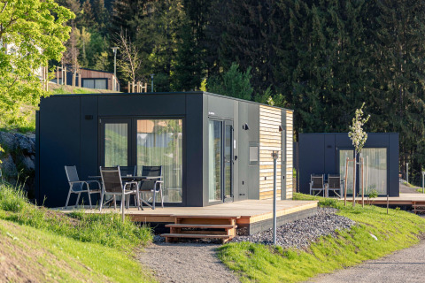 Moderne glamping-chalet i Nassfeld, Østrig, med udendørs terrasse og naturskøn udsigt til skov.