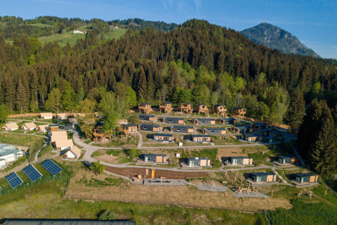 Luchtfoto van Chalets & Glamping Nassfeld 3 in Oostenrijk, omgeven door bergen, bos en natuur.