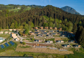 Luchtfoto van Chalets & Glamping Nassfeld 3 in Oostenrijk, omgeven door bergen, bos en natuur.