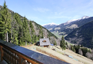 Udsigt fra en balkon over det naturskønne alpine landskab ved Chalet «Pirkach» i Østrig med bjerge.