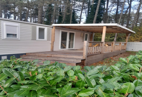 Una casa mobile con veranda coperta e terrazza in legno nella foresta di Verblijfpark Breebos 2.
