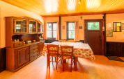 Dining room at lodge «Les Bouleaux» in Belgium with wooden furniture, china cabinet and tablecloth.