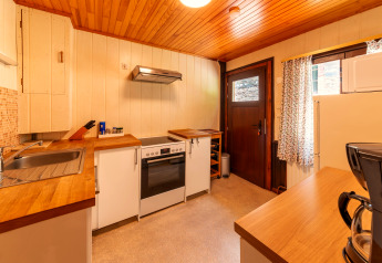 Warm wooden kitchen at lodge 'Les Bouleaux' in Belgium, featuring modern appliances and natural light.
