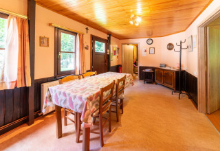 Eetkamer van lodge «Les Bouleaux» in België met houten meubels, ramen en een gezellige sfeer.