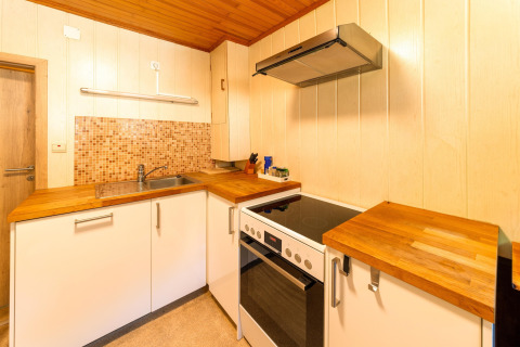 Moderne keuken met houten werkblad, fornuis en oven in de Les Bouleaux lodge, België.