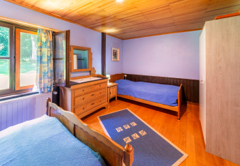 Bright bedroom at Les Bouleaux lodge in Belgium with two single beds, wooden furniture, and large windows.