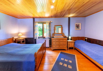 Bedroom at Les Bouleaux lodge in Belgium with wooden beds, blue bedspreads, and warm cozy ambiance.