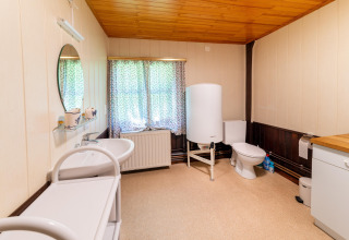 Badkamer in lodge «Les Bouleaux» in België met wastafel, toilet, boiler en opbergkast.