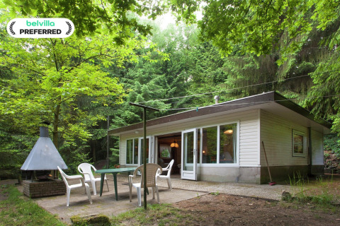 Forest House the Squirrel lodge exterior with patio, outdoor furniture, grill and surrounded by lush forest.
