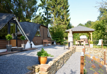 Außenbereich des Chalets 'Mise Au Vert' in Belgien mit Terrasse, Pavillon und grüner Umgebung.