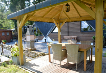 Gedeckter Terrassenbereich am Chalet 'Mise Au Vert' in Belgien mit Holztisch und Stühlen.