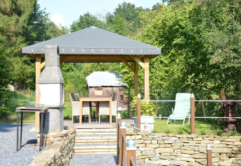 Udendørs terrasse ved chalet 'Mise Au Vert' i Belgien med pavillon, havegrill og spiseområde om sommeren.