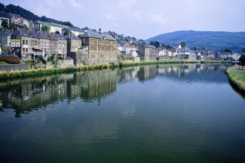 Uitzicht vanuit chalet 'Mise Au Vert' op rivier, historische huizen en heuvels in België.