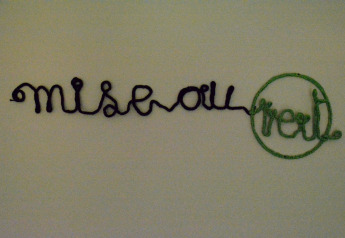 Künstlerisches 'Mise au Vert' Schild aus Schnur an der Wand in einem Chalet in Belgien, drinnen fotografiert.