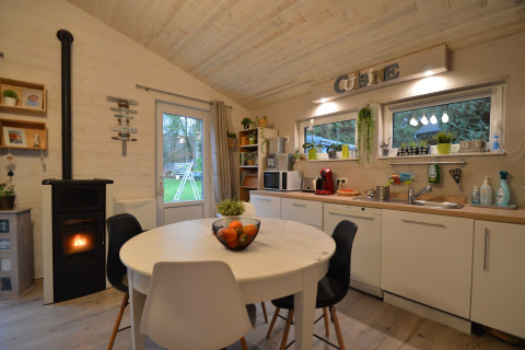 Moderne keuken en eethoek in Chatillon 67 lodge in België, met houtdecoratie en gezellige haard.