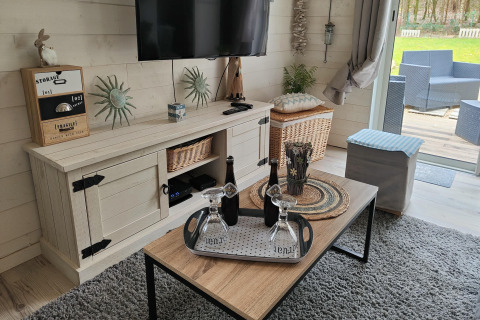 Woonkamer in lodge Chatillon 67 in België met tv, salontafel en uitzicht op het buitenterras.