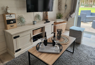Woonkamer in lodge Chatillon 67 in België met tv, salontafel en uitzicht op het buitenterras.