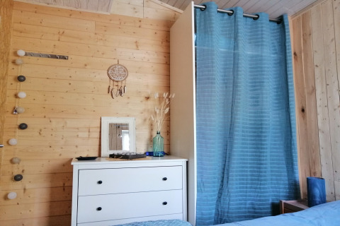 Gezellig houten lodge-interieur met dressoir, spiegel en blauwe gordijn bij Chatillon 67 in België.
