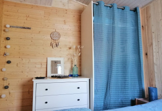 Gezellig houten lodge-interieur met dressoir, spiegel en blauwe gordijn bij Chatillon 67 in België.